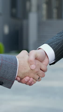 Vertical Format Video of the hands of top managers in business suits. Shake hands with each other, agree to a deal or say hello. Unrecognizable person