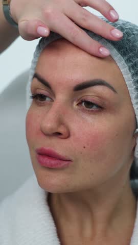A cosmetologist shows problem areas on a woman's face before the procedure. Facial skin cleansing, beauty procedures and self-care in cosmetology. High quality 4k footage