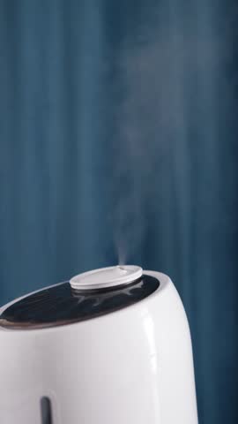 Humidifier provides healthy humidity levels in bedroom. Steam of fine mist dispersing into air from ultrasonic humidifier. Health care concept vertical video.
