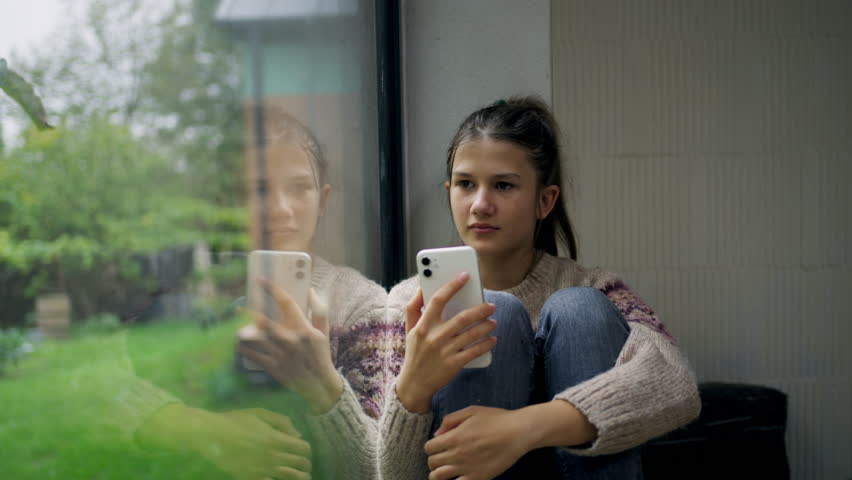 Teenage girl crying after reading cruel text. Teen depression.