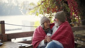Elderly married couple sitting on coffee shop terrace on beautiful autumn day, enjoying cup of coffee in the autumn atmosphere. - Powered by Shutterstock - Get 15% off with code: PIKWIZARD15
