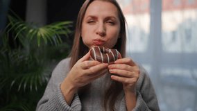 Sweet addiction concept. A woman eats a chocolate donut with morbid delight. - Powered by Shutterstock - Get 15% off with code: PIKWIZARD15