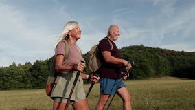 Active couple spending their free time outdoors, hiking in nature. Senior man and woman with trekking poles and backpack. - Powered by Shutterstock - Get 15% off with code: PIKWIZARD15