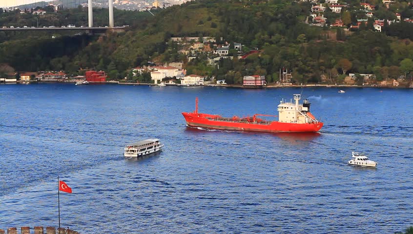 Bosporus seascape with a cargo ship, tour boat and a leisure craft. Red