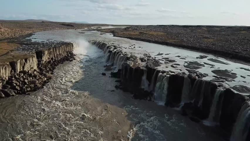 Aerial perspective captures the raw beauty of Selfoss waterfall in Iceland. Showcasing the water cascading over basalt columns into a powerful river. Creating a dramatic display of nature