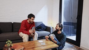 Gay couple playing cards and having fun at home - Powered by Shutterstock - Get 15% off with code: PIKWIZARD15