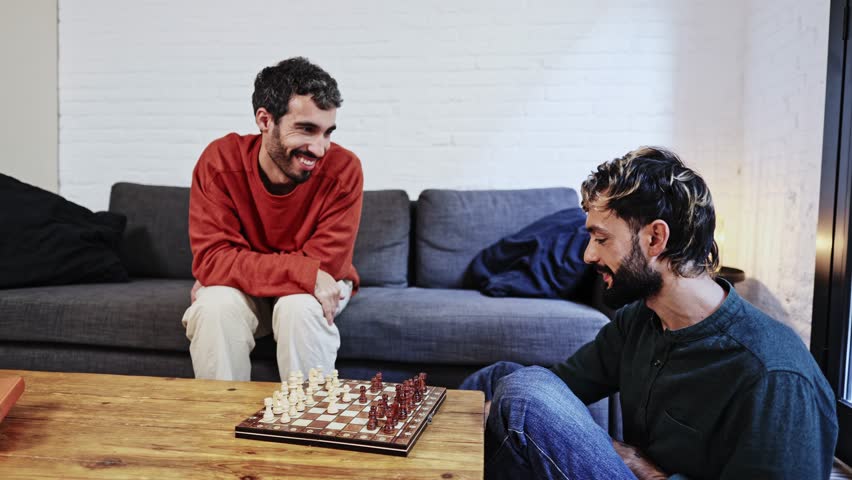 Gay couple playing chess at home - Powered by Shutterstock - Get 15% off with code: PIKWIZARD15