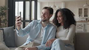Smiling Interracial Couple Relaxing On Couch Enjoying Happy Video Call At Home - Powered by Shutterstock - Get 15% off with code: PIKWIZARD15