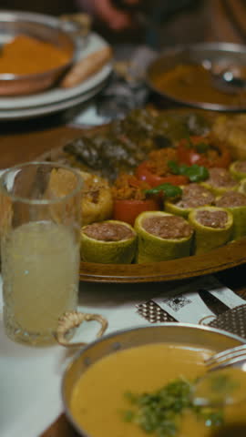 Vertical Screen: traditional Middle Eastern and Turkish meal served on a wooden platter, featuring dolma with stuffed zucchini, tomatoes, and grape leaves. Authentic cuisine, homemade dishes, iftar