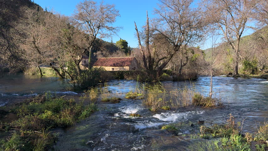 Slow flowing wide river in sunny winter day at Krka National Park, Croatia