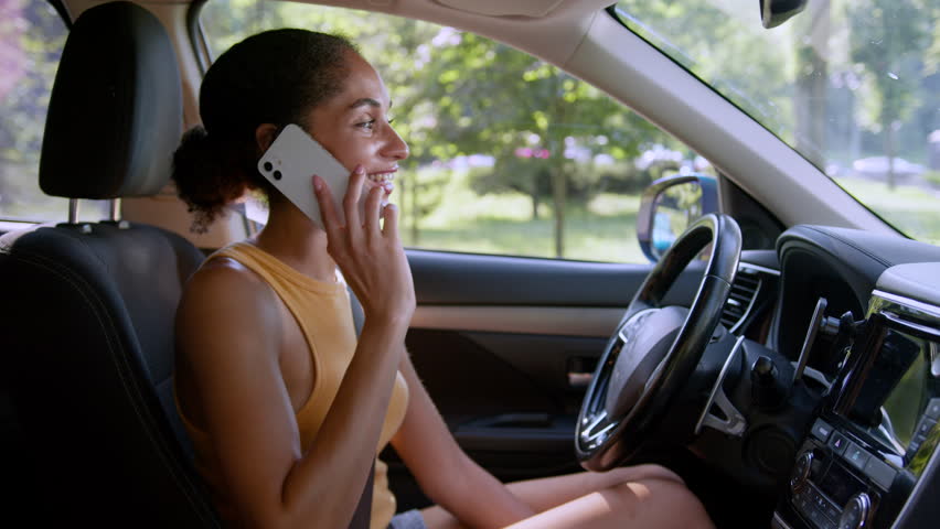 African American woman female girl businesswoman car auto automobile vehicle driver talking mobile phone smartphone cellphone call answer communication chatting business gadget speak transportation