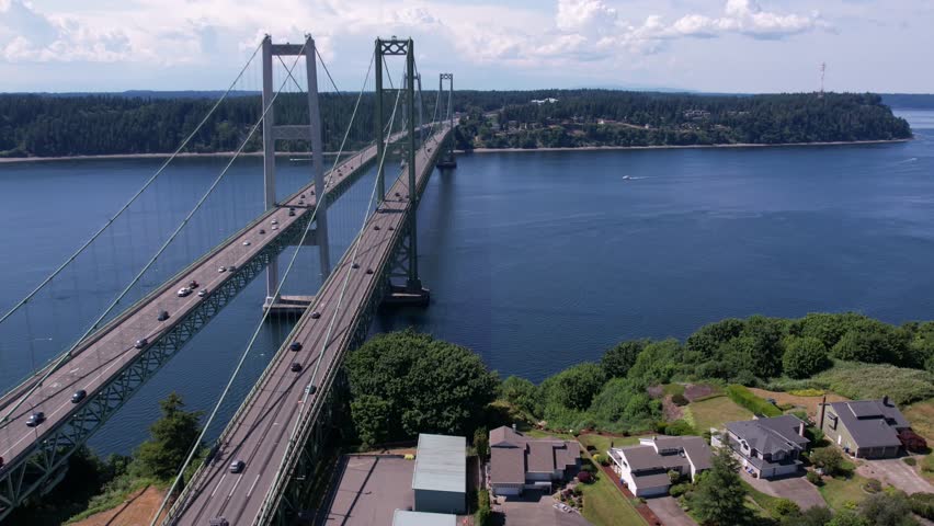Drone timelapse of Tacoma Narrows Bridge during the day with car traffic and boats in Pierce County, Washington, USA