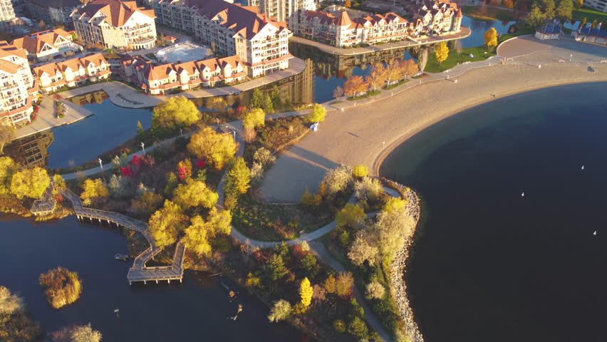 Downtown Waterfront, Kelowna, BC, Canada. Panorama Calm Okanagan Lake Landscape. British Columbia Interior in the Fall Autumn Season with Colourful Trees. Evening Sunset, City Park Walking Path