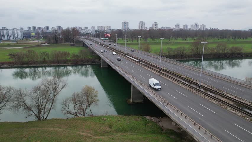Closeup 4K aerial view of the famous Bridge of Youth (Most Mladosti) over the river Sava in Zagreb, the capital city of Croatia, with the trams and vehicles driving over it.