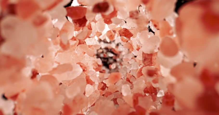 Himalayan pink salt is fallingin a super slow motion. Pink Himalayan salt is up to twenty times more expensive than table or sea salt. Shot on super slow motion camera 1000 fps.