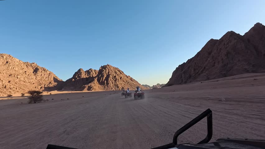 Quad bike ride through the desert near Sharm el Sheikh, Egypt.Adventures of desert off-road on ATV.Sand and Sand Borkhan. Rock and sunset. Quad Cycle Travel. Excursion with people.