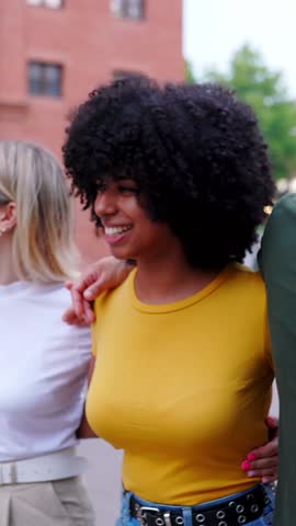 Vertical HD video of happy multiracial group of young people having fun together at city street. Millennial diverse tourist friends enjoying summer vacation in Italy. Youth community concept.