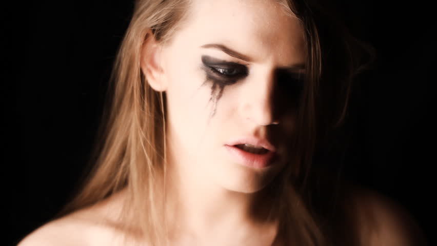 sad woman in tears in studio on a black background