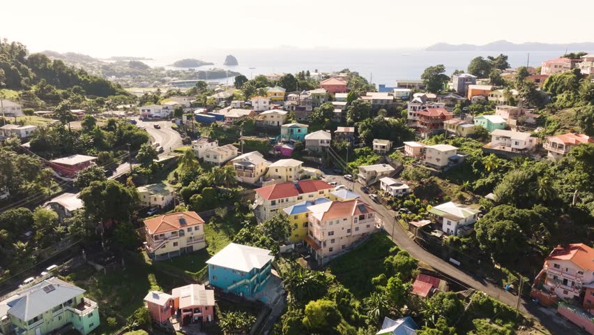 Aerial drone shot of city in Kingstown St. Vincent and the Grenadines, vibrant colored homes on the top of the hillside overlooking islands
