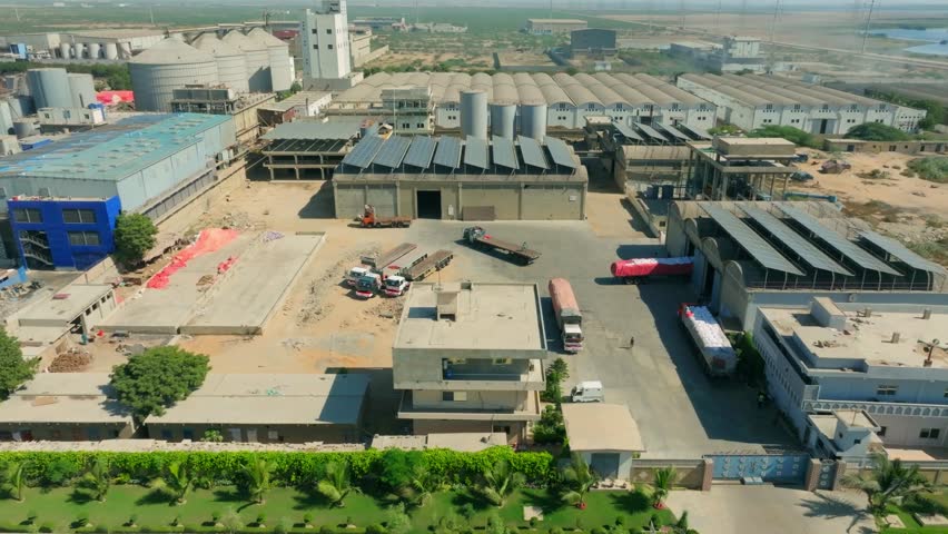 Aerial view of solar panels installed on the roof of an industrial factory in Karachi, Pakistan, promoting renewable energy and sustainability. push forward shot