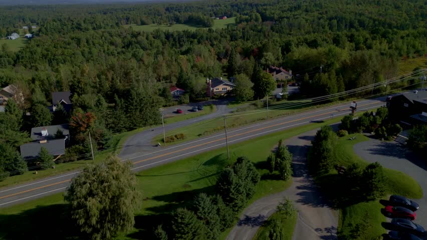 Sutton's lush forests breathtaking aerial view, scenic landscapes and charming homes in Quebec, Canada, drone pushes towards to nature's tranquility and rural beauty.