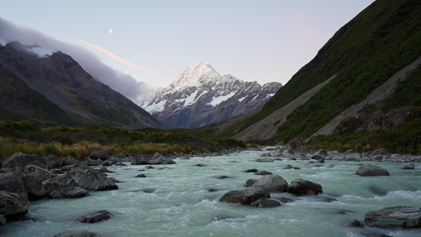 Majestic landscape of Mount Cook with the moon and stream flowing in the evening at Hooker valley track, New Zealand