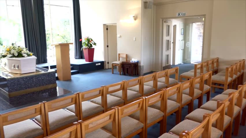 shot of a funeral casket or coffin placed on a catafalque platform ready to be lowered in a chapel or church
