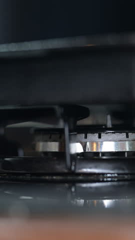 Close up of gas is switching on, appearing fire flame. Gas blue stove flame. Propane butane in the restaurant kitchen and home heating. Oil and gas industry, crisis, resources, economy concept. Slow