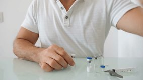 49 year old Brazilian man diluting growth hormone medication to be administered. - Powered by Shutterstock - Get 15% off with code: PIKWIZARD15