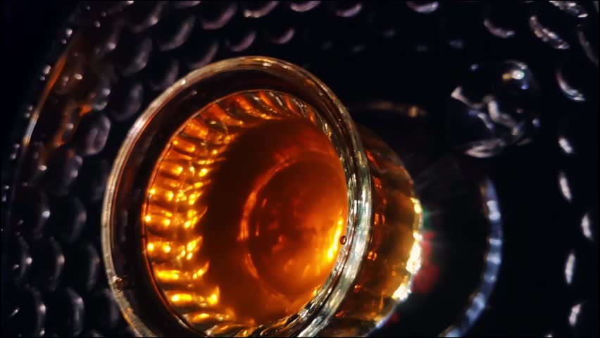 Slow Motion Spiral Shot of Glass with a Black Tea and Light Underneath Abstract Art Video Stock Footage 1080