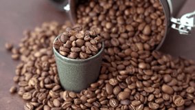 A large bucket spills a heap of coffee beans onto a wooden table, with an overflowing small cup amidst the scattered beans. The rich, dark beans contrast beautifully with the rustic wood surface. - Powered by Shutterstock - Get 15% off with code: PIKWIZARD15
