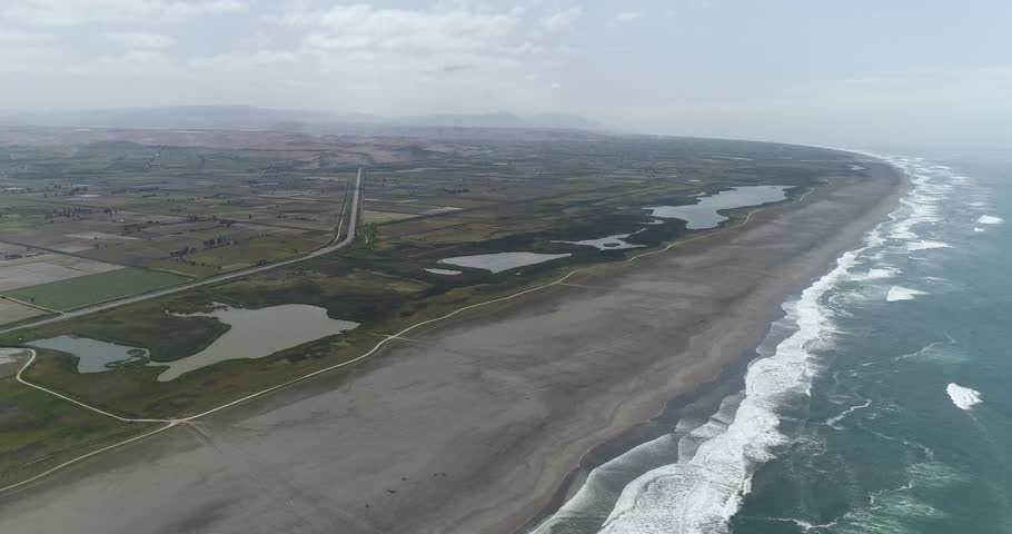A breathtaking aerial view of wetlands meeting the ocean. A blend of sand, water, and greenery, ideal for travel blogs, conservation projects, and editorial use. Mejia, Arequipa, Peru.