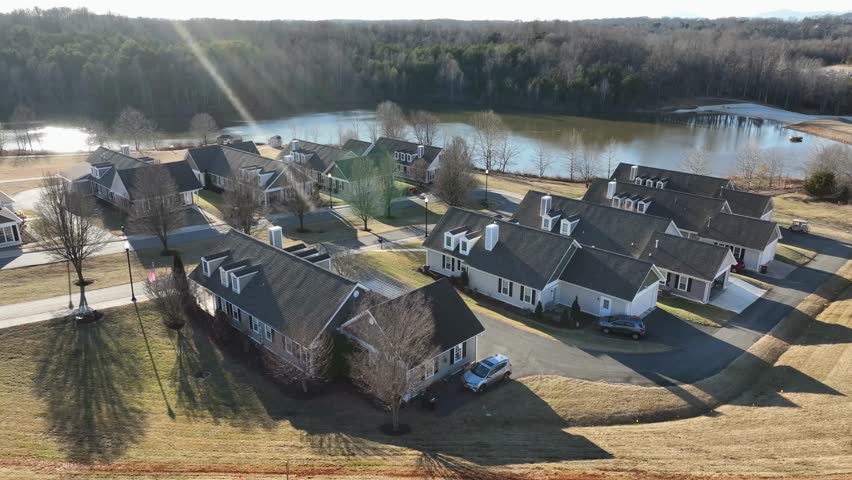 Large single family homes with private lake in suburb district of american town. Sunny day in winter season. Forest in background. Expensive housing area of Lynchburg, Wyndhurst.