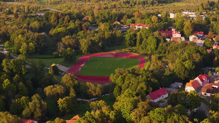 Aizpute Sports And Recreation Center. Aerial Zoom In On Cross Country Track And School Athletic Field In The Old Historic Town In Kurzeme, Latvia.