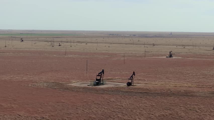 Oil field in Texas with oil pumps working in the barren landscape