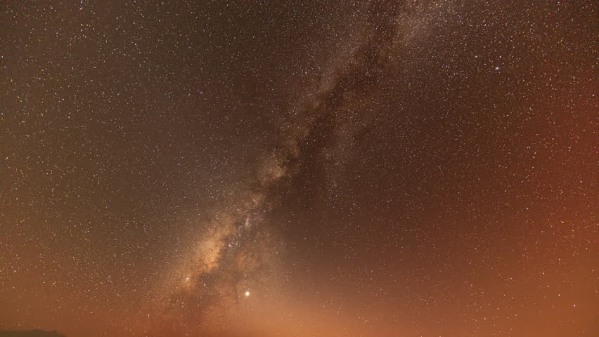 Time lapse Milky Way above mountains at night in autumn. Landscape with mountain valley, low clouds, purple starry sky with milky way. The Milky Way shines on a cold night in the north of Thailand