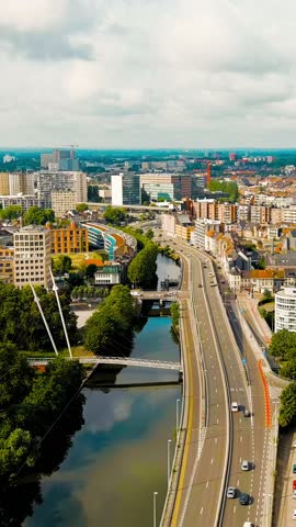 Vertical video. Ghent, Belgium. Esco (Scheldt) river embankment. Panorama of the city from the air. Cloudy weather, summer day, Aerial View. Rich colors