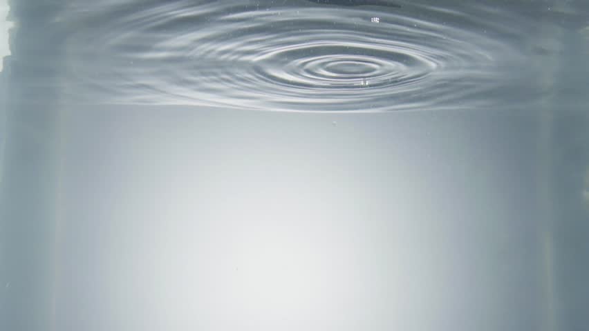 Man hand dropping bitter melon into clear water in slow motion against gray background - Powered by Shutterstock - Get 15% off with code: PIKWIZARD15