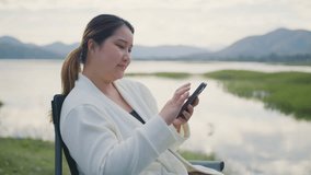 Attractive Freelance Woman Relaxing and Working Remotely in Nature, Happy Female Professional on a Video Call, Tech-Savvy Female Learning Online. Young Woman Reading and Communicating a Tablet - Powered by Shutterstock - Get 15% off with code: PIKWIZARD15