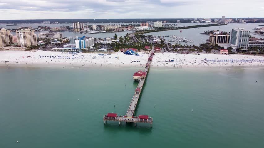 Pier 60 at Clearwater Beach in Florida, United States. Aerial beach landscape with Pier 60 catwalk structure extending over turquoise Gulf waters. Scenic summer coastline and vacation destination