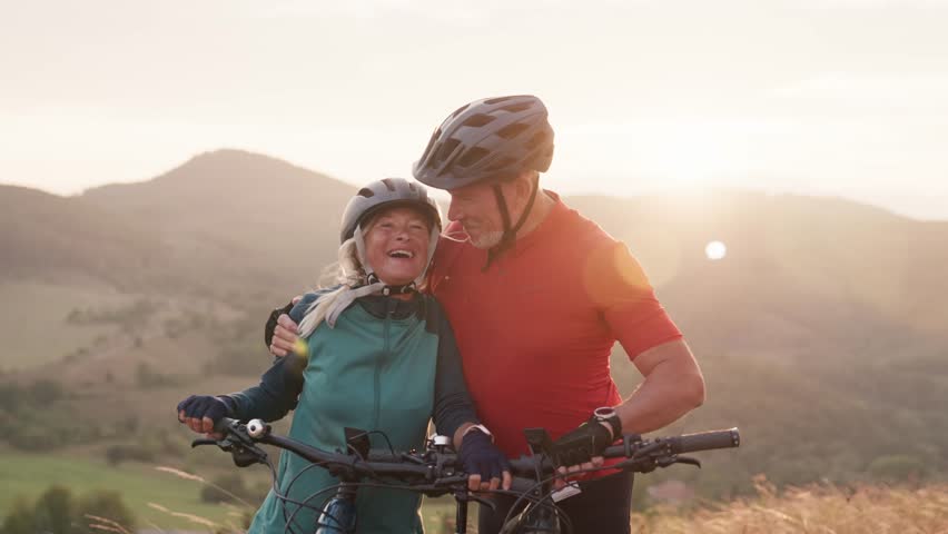 Video of beautiful senior couple on bike ride in autumn nature.
