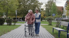 Senior woman and home caregiver spending a chilly, windy day outdoors in city park. Autumn walk for elderly patient with walker. - Powered by Shutterstock - Get 15% off with code: PIKWIZARD15