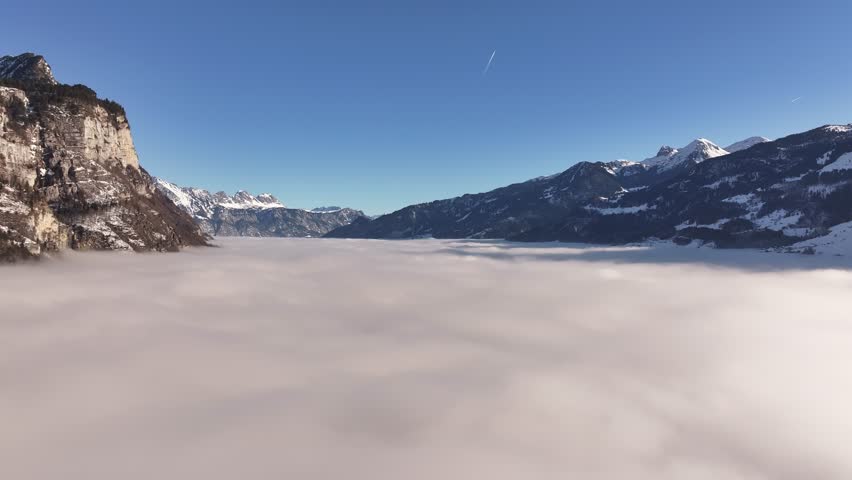 Cloud-covered valley with snow-capped mountains near Amden, Switzerland