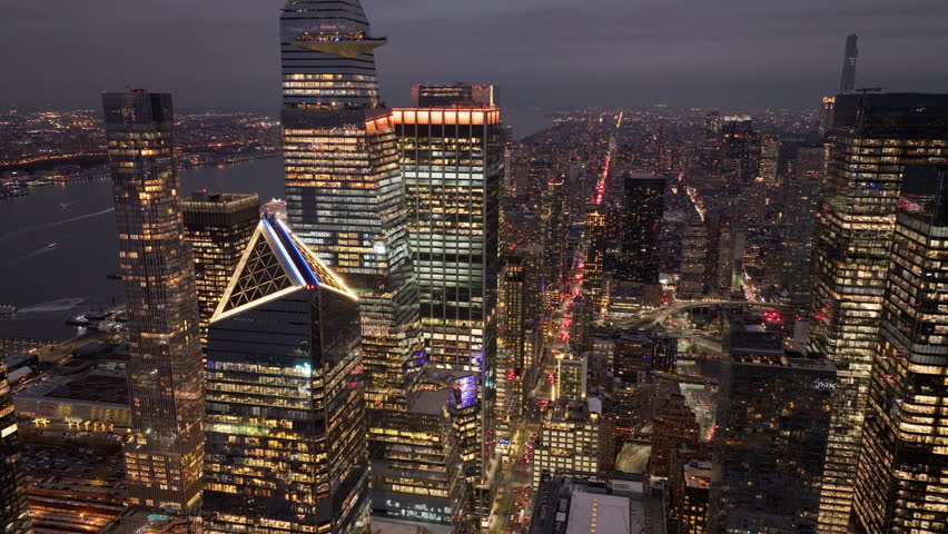 Urban landscape of New York City reveals glowing skyscrapers of Hudson Yards, bustling streets, and the mesmerizing cityscape at dusk