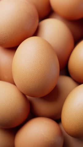 Rotating chicken eggs. Uncooked brown eggs. Close-up of hen eggs. Pile of farm fresh eggs. Cinematic shot. Closeup in 4K, UHD