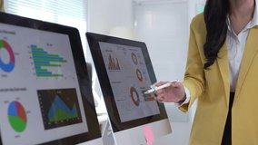 Professional businesswoman presenting financial data through interactive digital display, analyzing corporate performance with charts and graphs in modern office setting - Powered by Shutterstock - Get 15% off with code: PIKWIZARD15