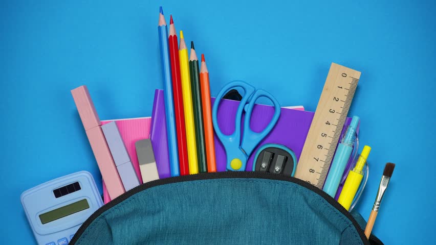 From the school bag appear notebooks, pencils and pens and other school supplies. Back to school concept. Stop motion