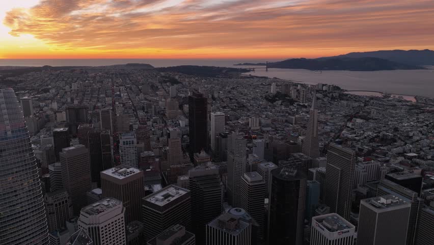 Orange, cloudy sunset sky over San Francisco cityscape with Golden Gate Bridge