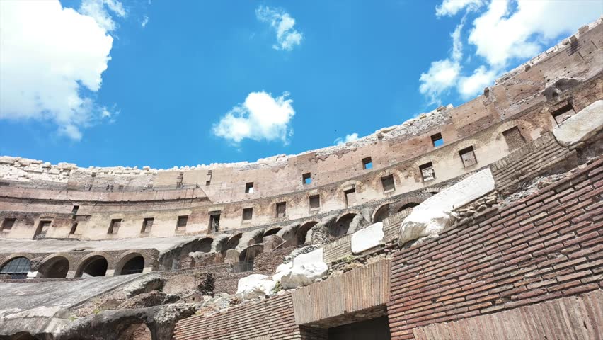 Timelapse of inside the Colosseum looking up at the blue sky and clouds in Rome, Italy