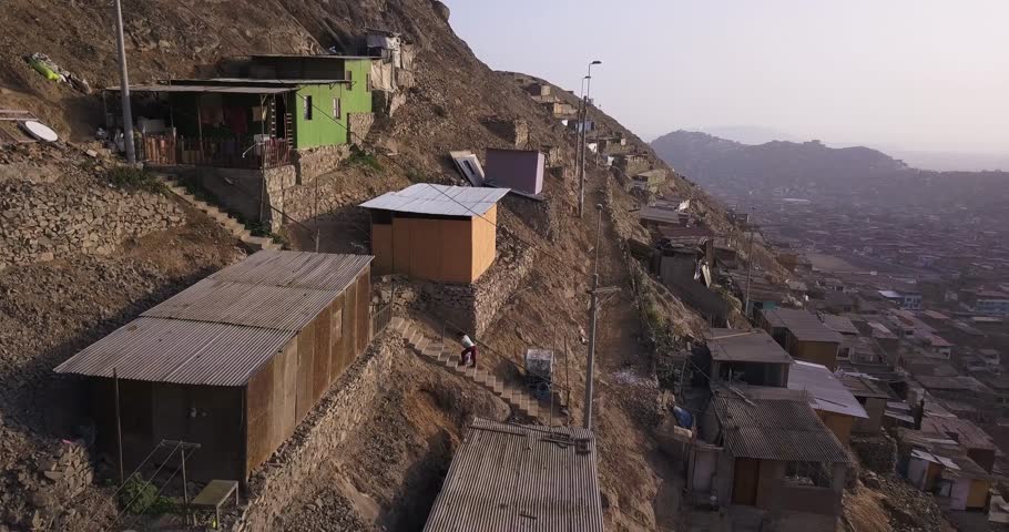 Precarious hillside dwellings with vibrant facades contrast against the harsh, arid landscape. A striking image for social studies, urbanization topics, and economic disparity projects.